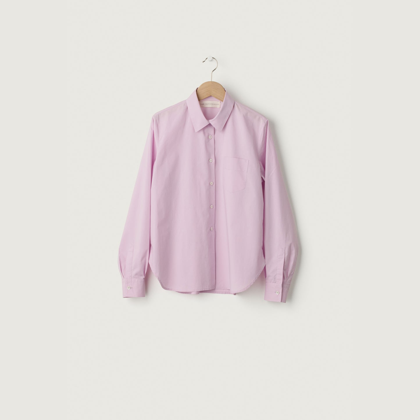 Pink shirt on a hanger against a white background