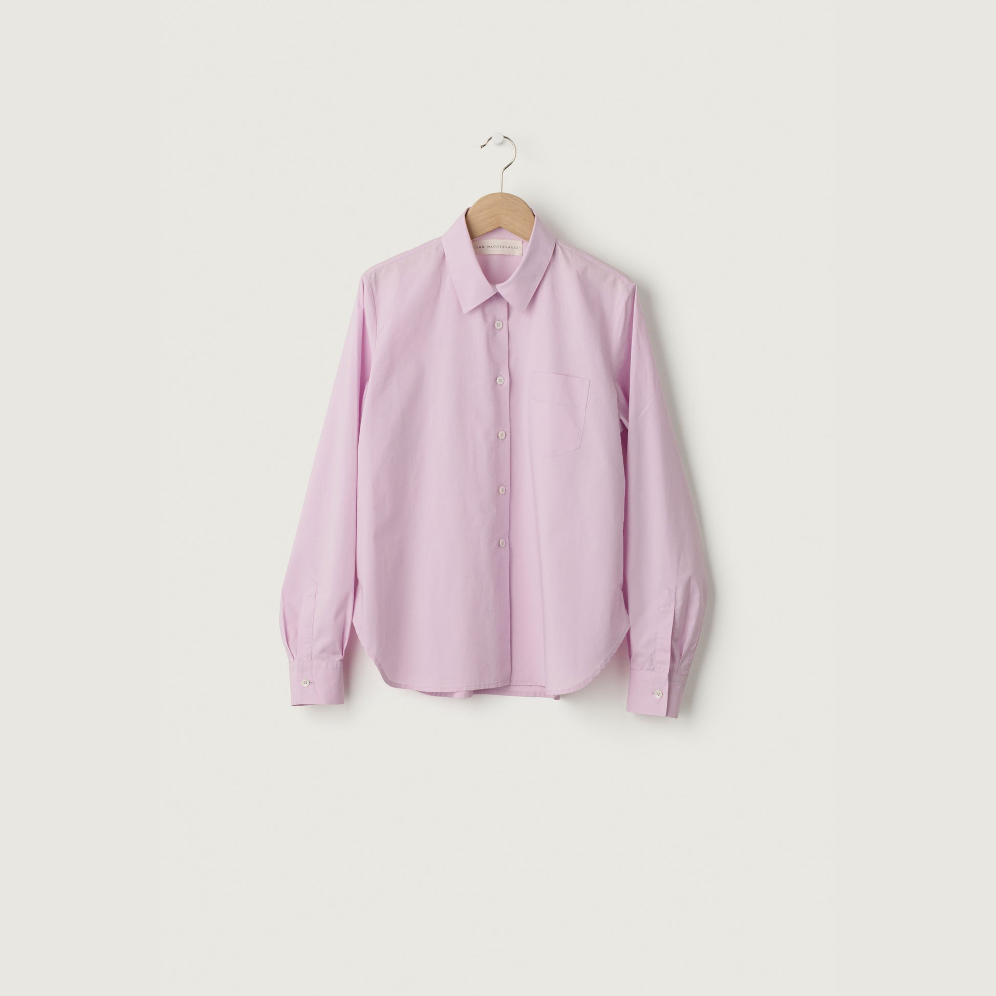 Pink shirt on a hanger against a white background